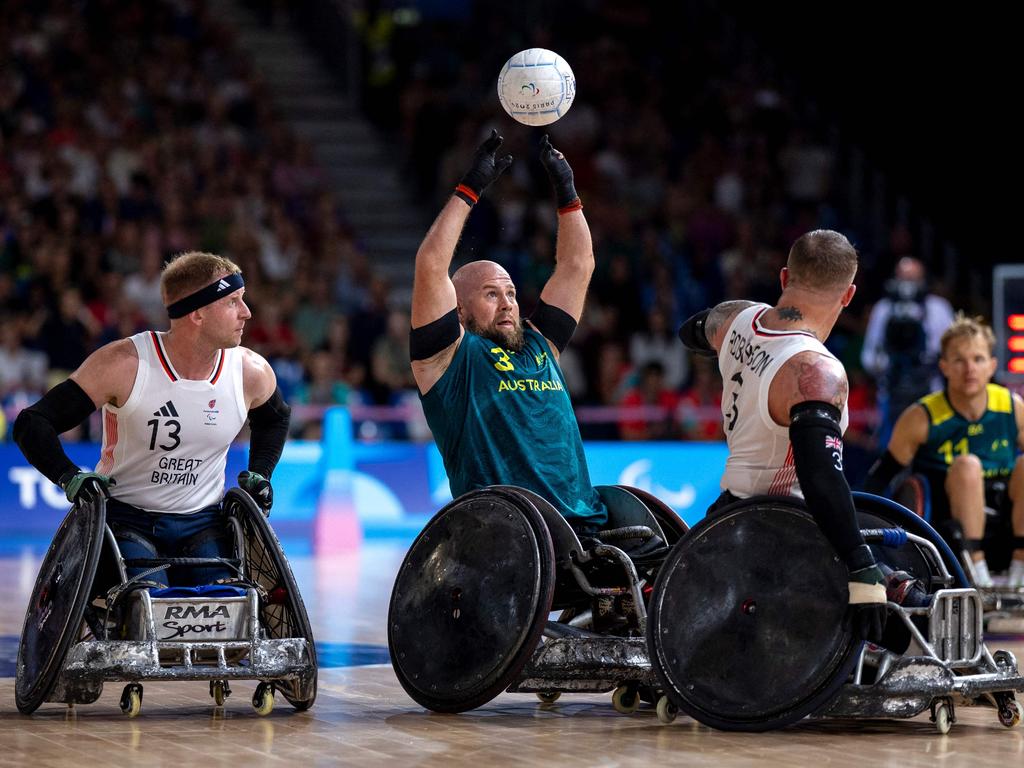 Australia's Ryley Batt, centre, catches the ball as Great Britain's Aaron Phipps, looks on. Picture: AFP Photo/OIS/IOC