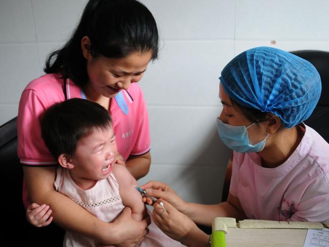 (FILES) This file photo taken on July 24, 2018 shows a child receiving a vaccination shot at the local disease control and prevention center in Jiujiang in China's central Jiangxi province. - China's Communist Party has sacked a dozen provincial and local officials and vowed to punish a pharmaceutical firm over a vaccine scandal that inflamed public fears over the safety of domestically produced drugs. The first political casualties fell on August 16, 2018 as a dozen officials were removed from office. (Photo by STR / AFP) / China OUT