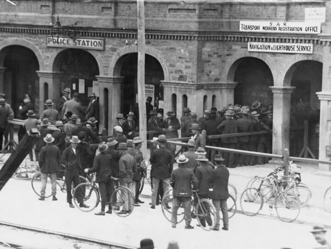 Volunteers queue outside the Port Adelaide Police Station in 1928 to register to as free labourers, offering their services to unload ships and work on the docks during the strike. Picture: State Library of South Australia