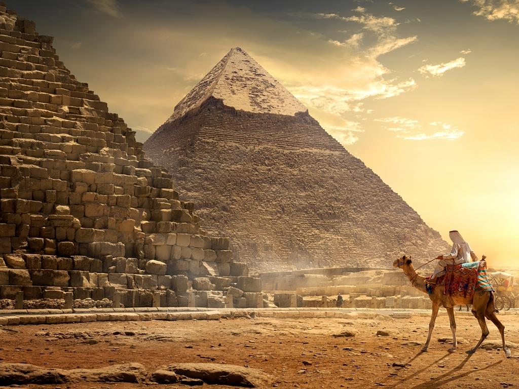 SUNDAY ESCAPE. PAUL EWART WISHLIST. SECRET WAYS TO SEE ICONIC ATTRACTIONS. Nomad on camel near pyramids in egyptian desert. Picture: iStock