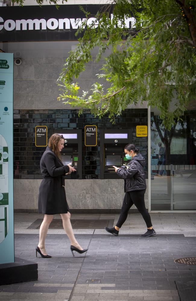 Shoppers on mobile phones walk past the Commonwealth Bank Branch at the Rundle Mall Adelaide, South Australia. Picture NCA NewsWire / Emma Brasier.