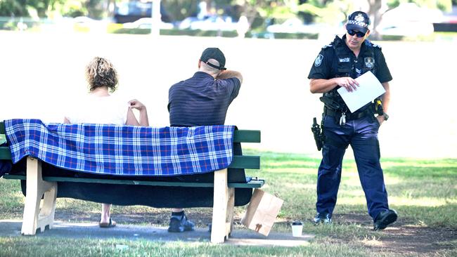 Police talk to people about social distancing in New Farm Park. Picture: AAP/John Gass