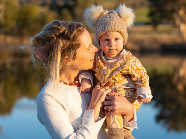 BOWNA, AUSTRALIA - The Australian. 13 July 2022 : Freelance writer Virginia Tapscott from Bowna near Albury. Virginia has written a very personal piece about her decision to be a stay at home mum, and how she feels she is undervalued for the work she puts in. Pictured with one of her 4 children, Tully 8mths.Photo by - Simon Dallinger