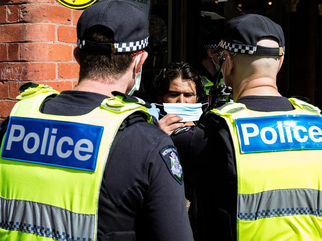 A man refuses to wear a mask issued to him by Victoria Police at the Queen Victoria Market on September 13, 2020 in Melbourne. Picture: Getty