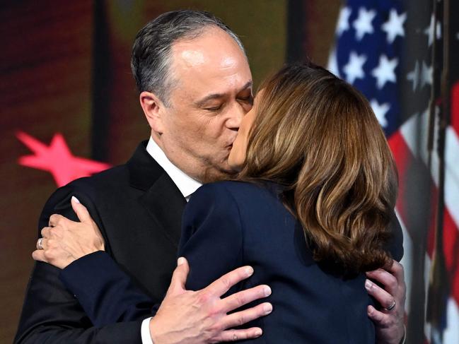 TOPSHOT - US Second Gentleman Douglas Emhoff (L) kisses US Vice President and 2024 Democratic presidential candidate Kamala Harris after speaking on the fourth and last day of the Democratic National Convention (DNC) at the United Center in Chicago, Illinois, on August 22, 2024. Vice President Kamala Harris will formally accept the partyâs nomination for president today at the DNC which ran from August 19-22 in Chicago. (Photo by ANDREW CABALLERO-REYNOLDS / AFP)