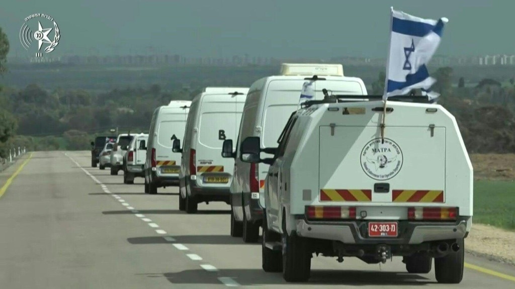 Palestinian militants carry one of four coffins during the handover of Israeli hostages' bodies in Gaza