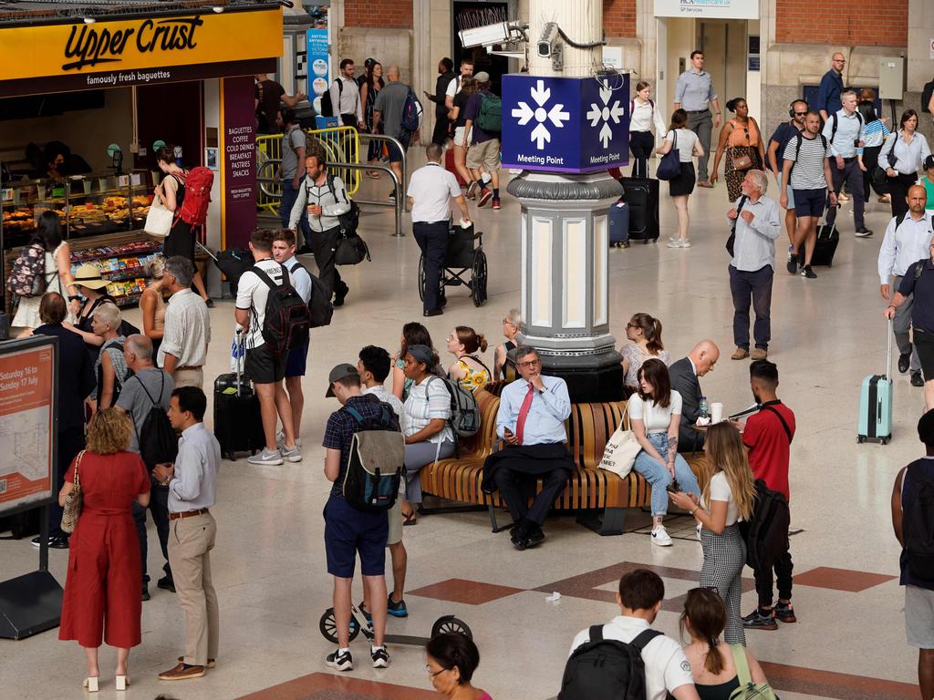 Commuters wait for their trains at Victoria Station in London. Picture: AFP