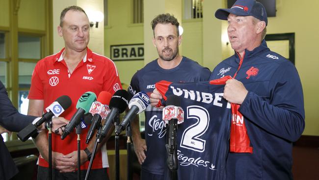 Swans coach John Longmire and Roosters coach Trent Robinson hand over Nick Davis. Photo: Tim Pascoe