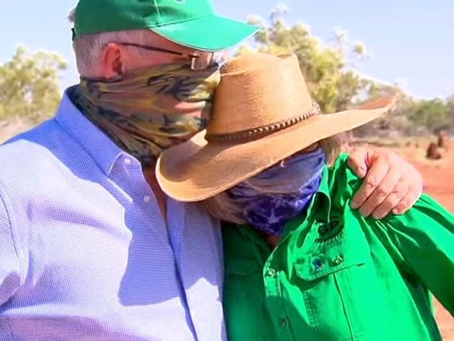 Prime Minister Scott Morrison comforts a grazier while inspecting dead cattle on her property near Cloncurry. The PM wore a face cover due to the overwhelming smell of dead cattle. Picture: ABC News