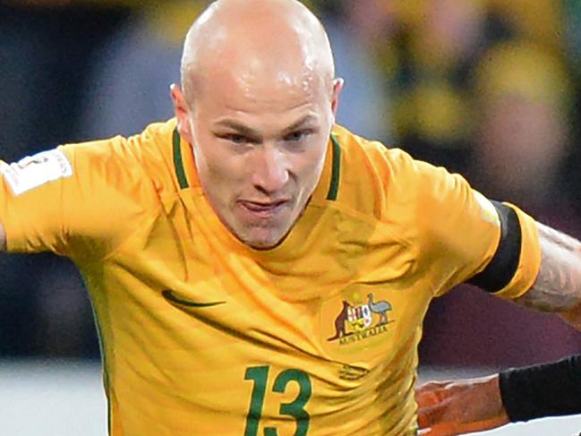 Aaron Mooy of Australia (C) fends off Pokklaw A-Nan of Thailand (R) during the World Cup 2018 qualifying football match between Australia and Thailand in Melbourne on September 5, 2017.  / AFP PHOTO / Mal Fairclough / -- IMAGE RESTRICTED TO EDITORIAL USE - STRICTLY NO COMMERCIAL USE --