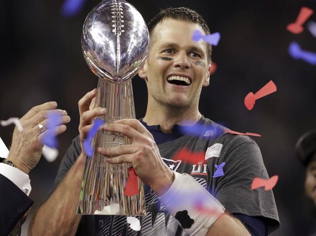 New England Patriots' Tom Brady holds the Vince Lombardi Trophy after defeating the Atlanta Falcons in overtime at the NFL Super Bowl 51 football game Sunday, Feb. 5, 2017, in Houston. The Patriots defeated the Falcons 34-28. At right is Patriots head coach Bill Belichick. (AP Photo/Darron Cummings)