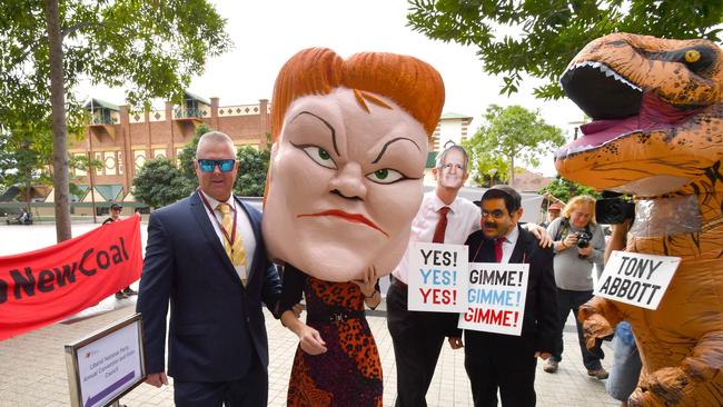 Protestors wearing masks depicting One Nation leader Pauline Hanson, Prime Minister Malcolm Turnbull and Gautam Adani are seen with a person in a dinosaur costume depicting former Prime Minister Tony Abbott outside the Queensland LNP (Liberal National Party) state convention at the Royal International Convention Centre, Brisbane, Saturday, July 7, 2018. (AAP Image/Darren England) NO ARCHIVING