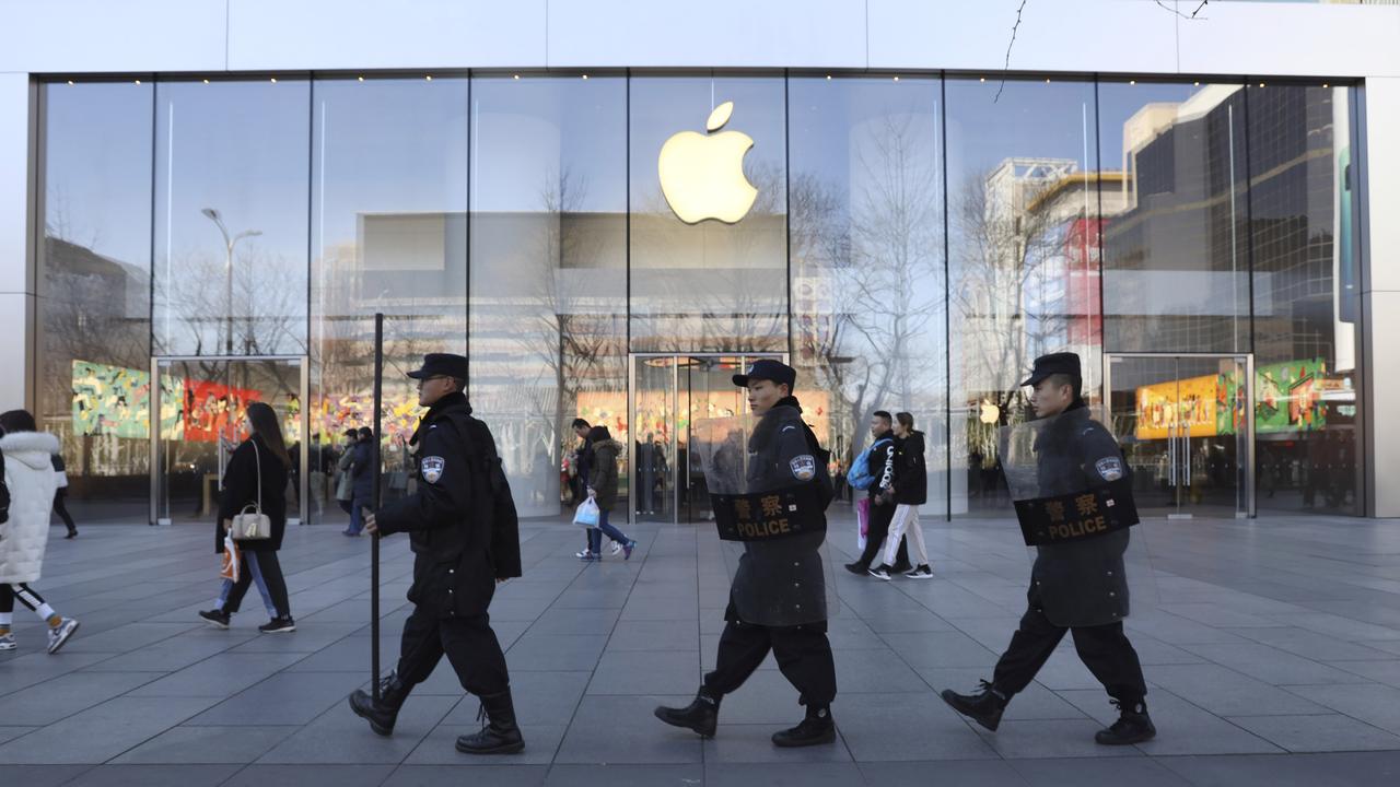 An ‘abundance of caution’ is behind Apple’s decision to temporarily close stores in China, like this one being patrolled by security guards in Beijing last year. Picture: AP Photo/Ng Han Guan