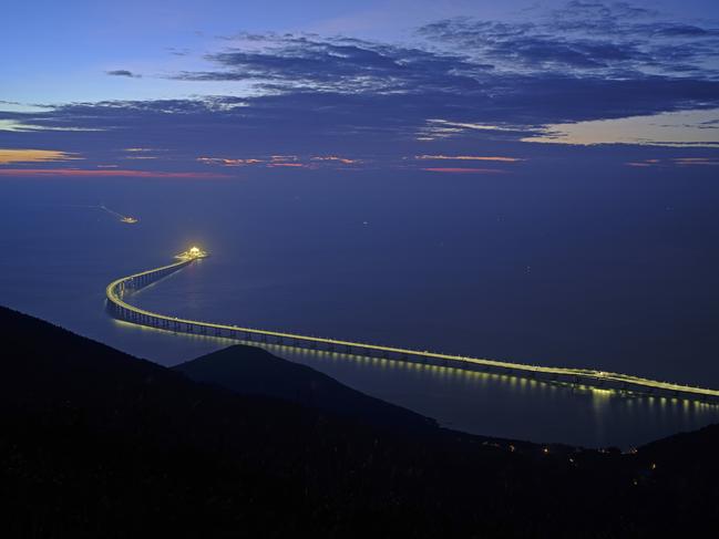 In this Sunday, Oct. 21, 2018, photo, the Hong Kong-Zhuhai-Macau Bridge is lit up in Hong Kong. The bridge, the world's longest cross-sea project, which has a total length of 55 kilometers (34 miles), will have opening ceremony in Zhuhai on Oct. 23. (AP Photo/Vincent Yu)