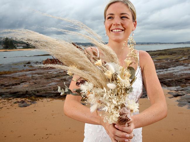 Dried and preserved flower bouquets are the new wedding trend with brides opting for everlasting blooms over fresh flowers. Jess Vanslambrouck who married recently pictured at Long Reef with her wedding bouquet. Picture: Toby Zerna