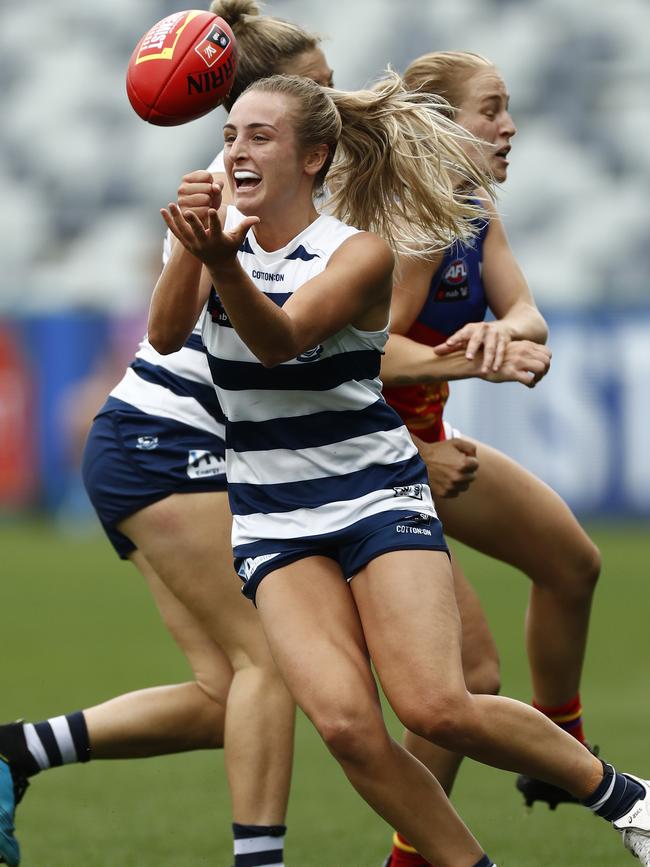 Geelong’s Amy McDonald handballs under pressure with support from a teammate.