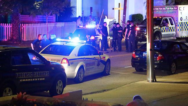 A man kneels across the street from where police gather outside the Emanuel AME Church. Picture: Wade Spees/The Post And Courier via AP