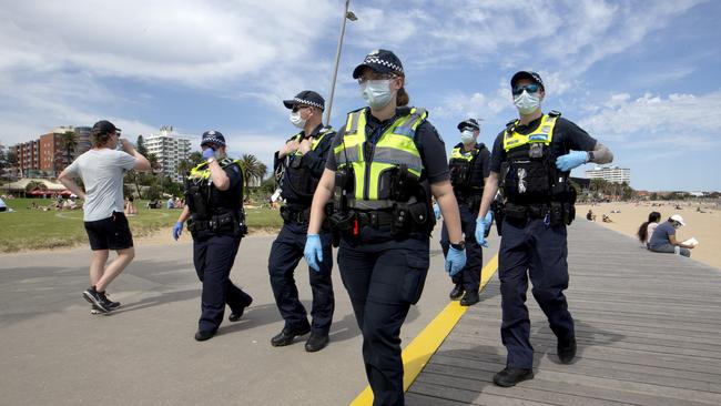 Police officers walk among beachgoers at St Kilda. Picture: NCA NewsWire / David Geraghty