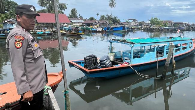 An Indonesian police officer guards the boat that flipped while carrying the four Australians. Picture: Amanda Hodge