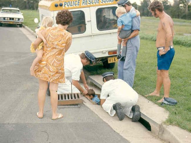 Police rescue officers pulling a boy out of a storm water drain, in western Sydney in the late 1970s. Picture: Supplied