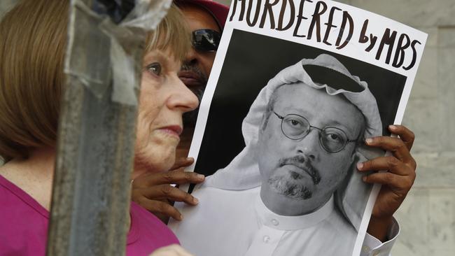 A woman holds a sign during a protest at the Embassy of Saudi Arabia over the disappearance of Saudi journalist Jamal Khashoggi, in Washington.