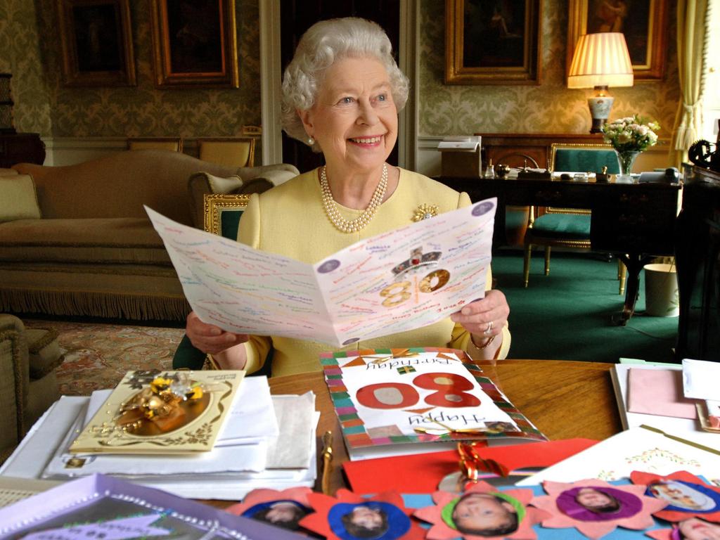 Queen Elizabeth II sits in the Regency Room at Buckingham Palace in London as she looks at some of the cards which have been sent to her for her 80th birthday. 19/04/2006. Picture: AFP