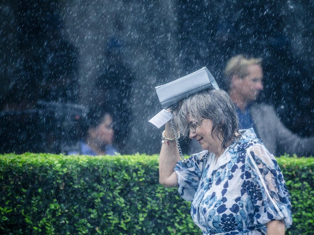 Heavy showers hit punters enjoying the Magic Millions Race Day at Aquis Park. Picture: Glenn Campbell