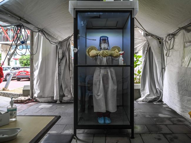 TOPSHOT - A health worker stands inside a non-contact chamber called the "CoV SHIELD" before taking swab samples to test for the COVID-19 novel coronavirus at Sunway Medical Center in Subang Jaya, on the outskirts of Kuala Lumpur, on October 22, 2020. (Photo by Mohd RASFAN / AFP)