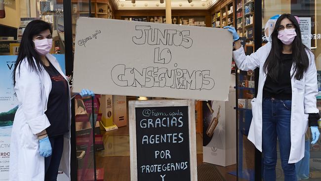 Workers in Madrid are seen outside a pharmacy to support caregivers with a banner with the words "Together we will get though it" as the lockdown continues due to the coronavirus outbreak. Picture: Carlos Alvarez/Getty