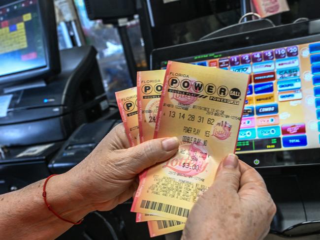 A woman holds Powerball lottery tickets inside a store in Homestead, Florida on July 19, 2023. The Powerball jackpot has reached 1 billion USD for the July 19, 2023, drawing, which has only happened two times before in the history of the game. (Photo by GIORGIO VIERA / AFP)