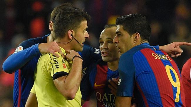 Barcelona's Uruguayan forward Luis Suarez (R) argues with referee after being shown the red card.