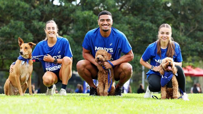 ASICS ambassadors Leanne Pompeani, elite long distance runner, and dog Kobe, Cronulla Sharks player Ronaldo Mulitalo and dog Kobe, and Western Sydney Wanderers player Amy Chessari and dog Benson. Picture: Tim Hunter