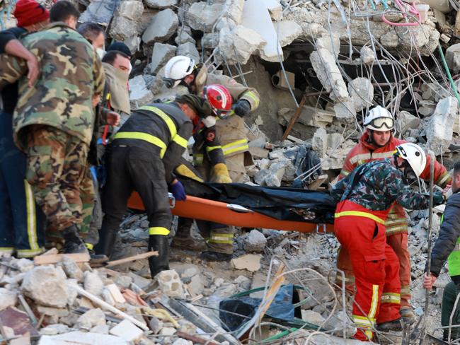 Rescuers carry on a stretcher the corpse of a victim retrieved from the rubble of a collapsed building, in the regime-controlled town of Jableh in the province of Latakia, northwest of the capital Damascus. Picture: AFP