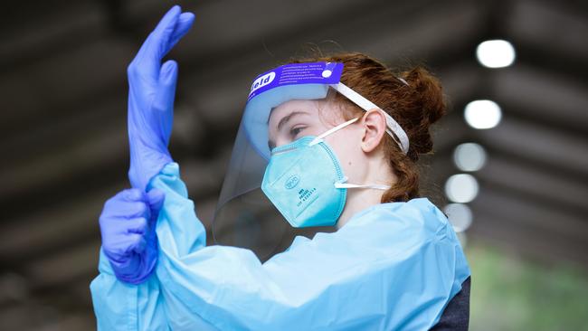 A nurse changes gloves at the Warringah Aquatic Centre COVID-19 testing centre in northern Sydney. Picture: Gaye Gerard