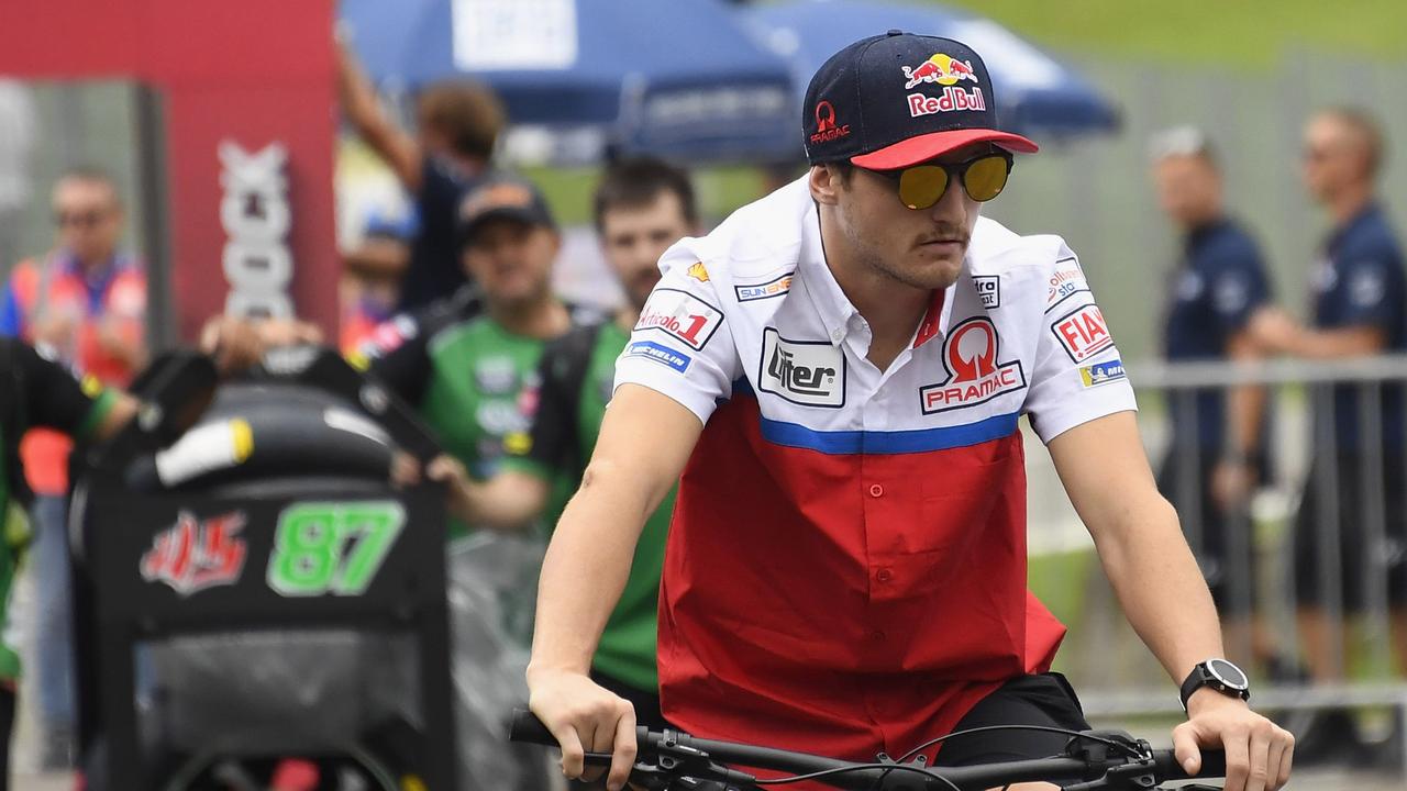 Jack Miller rides a bicycle in the paddock in Austria.