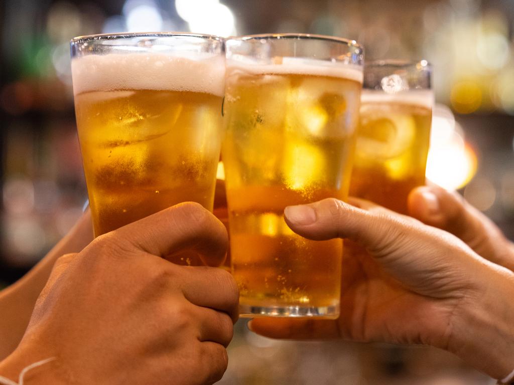 Group of happy friends drinking and toasting beer at brewery bar restaurant – Friendship concept with young people having fun together at cool vintage pub – Focus on middle pint glass