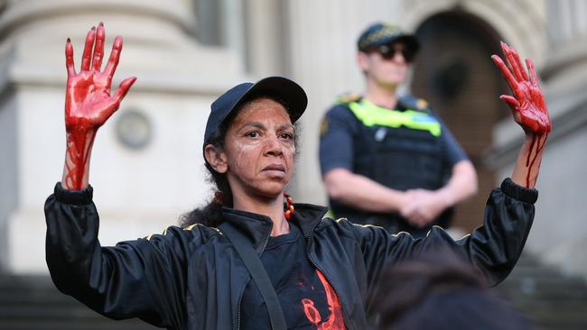 A woman with her hands painted red marching during a protest in Melbourne. Picture: AAP