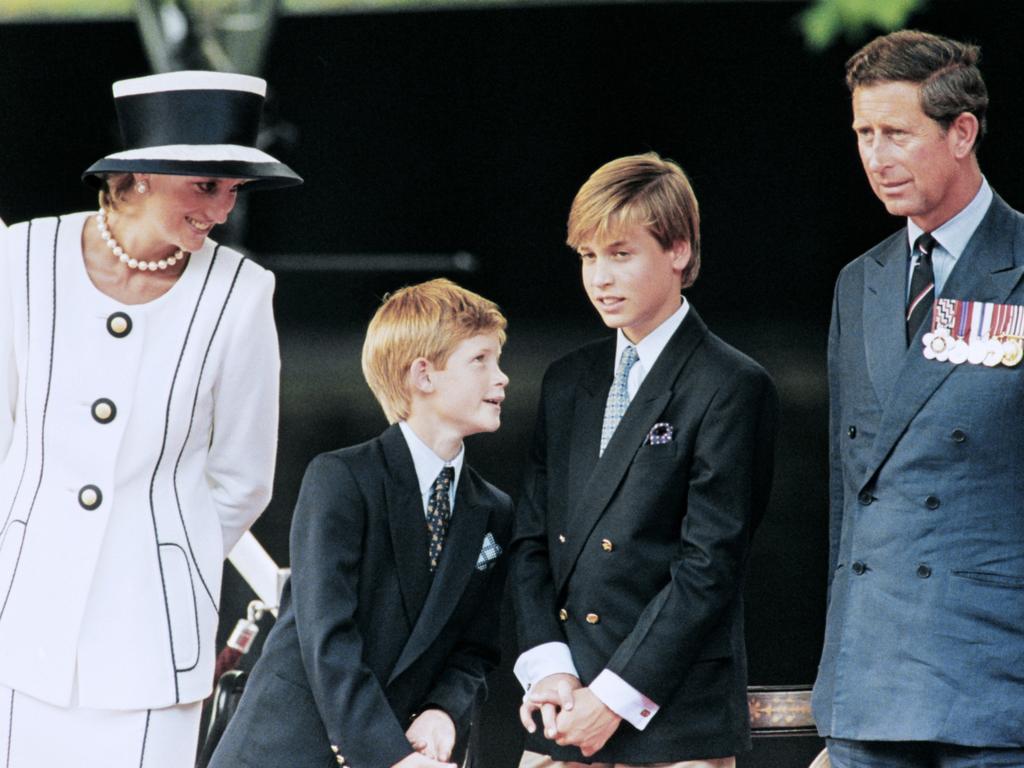 Prince Charles (L), Princess Diana (R) and their children William (2nd L) and Harry watch the march past on a dais on the mall as part of the commemorations of VJ Day on August 19, 1995. The commemoration was held outside Buckingham Palace and was attended by 15,000 veterans and tens of thousands of spectators. / AFP PHOTO / Johnny EGGITT