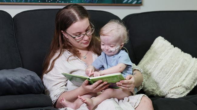 Toddler Colton Hughes-Hodges reading books with his mother Keeley Gear. Picture: Brendan Radke