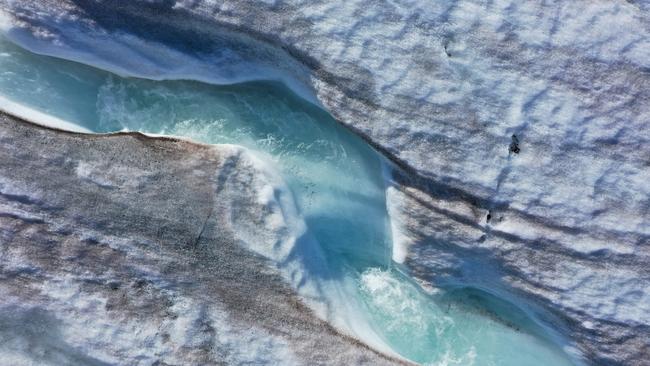 A drone captures the water as it carves a winding channel down the surface of the melting Longyearbreen glacier during a summer heatwave on Svalbard archipelago, near Longyearbyen, Norway. Picture: Getty