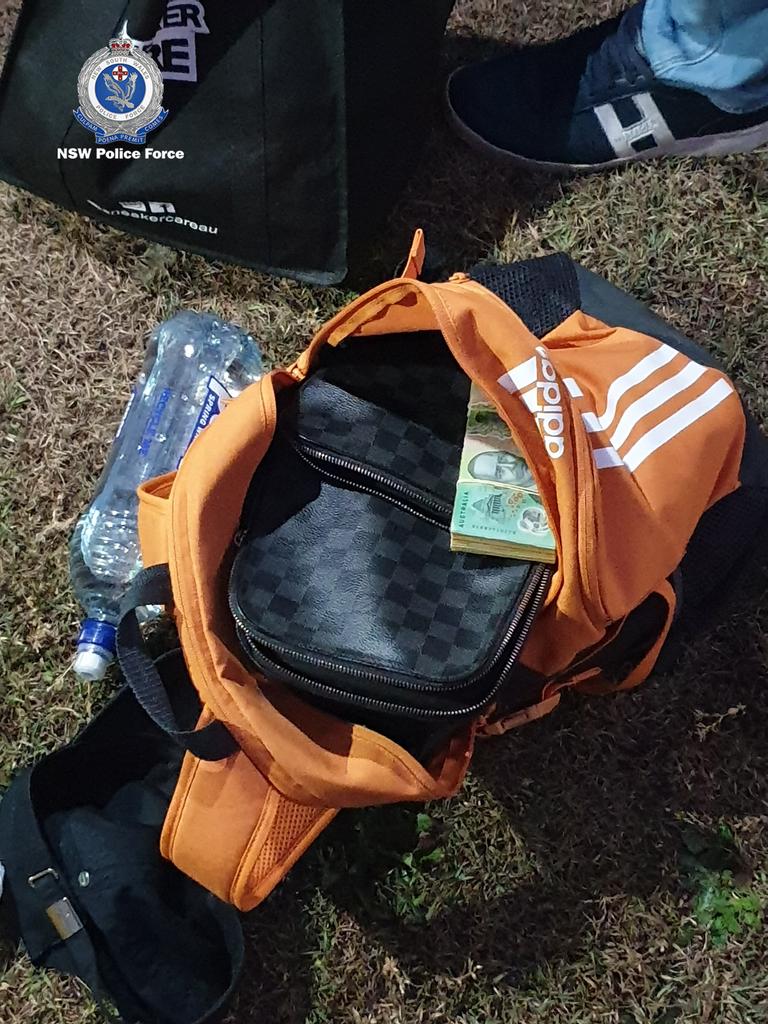 Wads of cash and other items can be seen inside a seized bag. Picture: Supplied