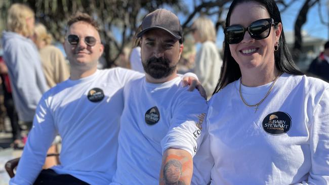 Balin Stewart’s brother, Jacob Stewart, and Balin’s parents, Michael and Kerri-Lyn Stewart, wearing long sleeved T-shirts bearing the Balin Stewart Foundation badge.