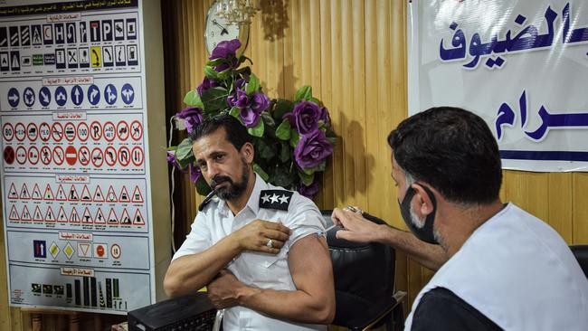 A medic administers a dose of the Pfizer-BioNTech Covid-19 coronavirus vaccine to a policeman during a health department vaccination campaign in Iraq's southern city of Nasiriyah on Wednesday. Picture: AFP