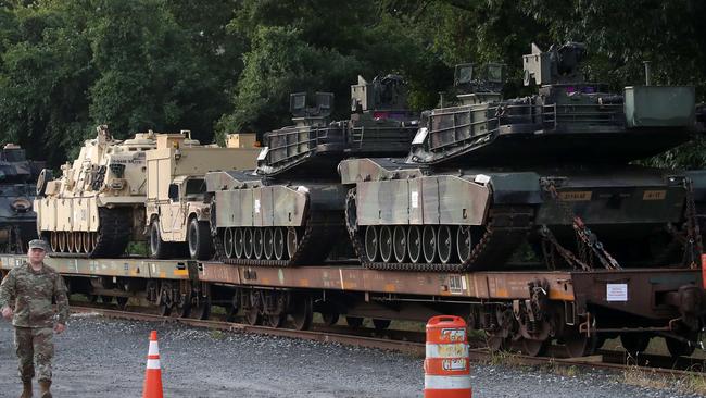 Two M1A1 Abrams tanks and other military vehicles sit on guarded rail cars as officials try to work out how to get them across Washington. Picture: AFP.