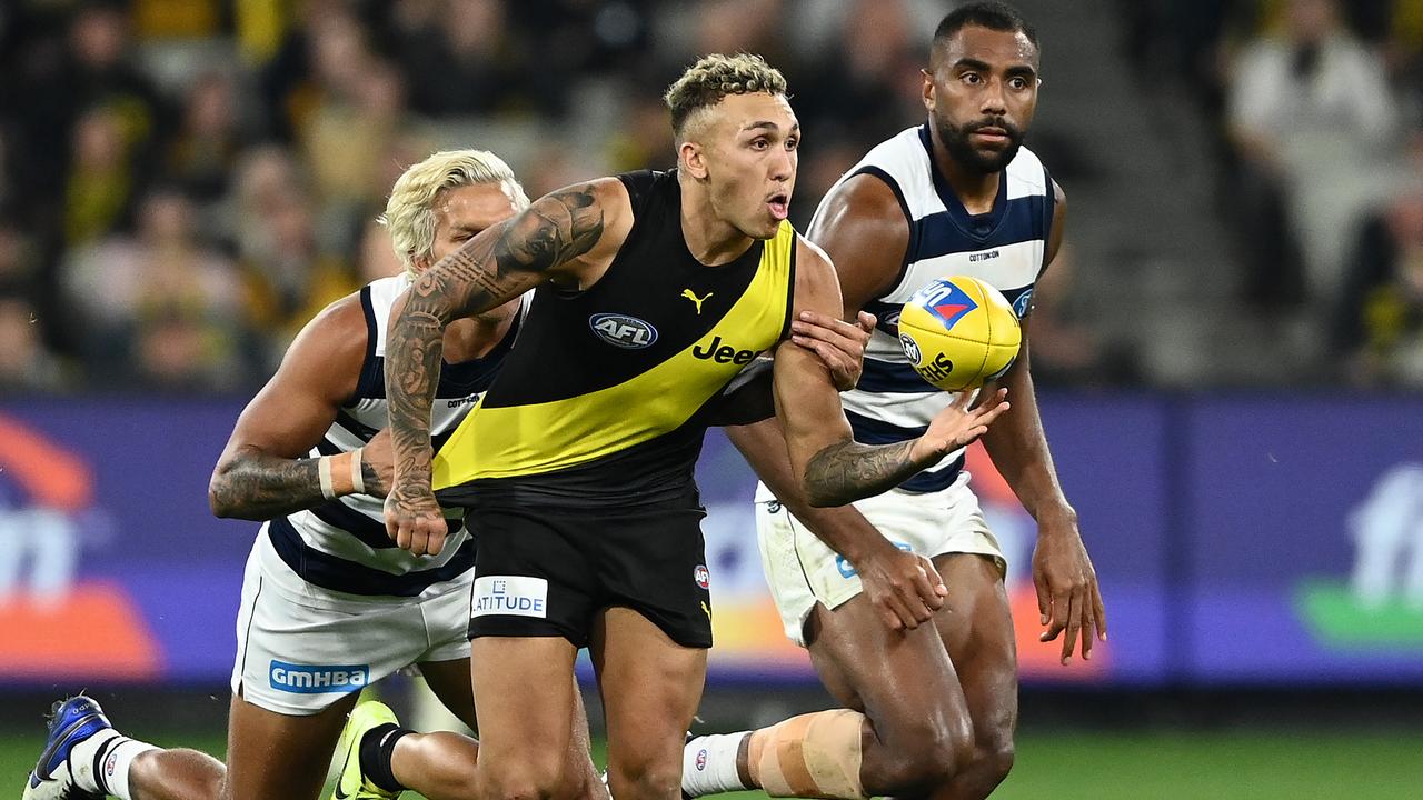 MELBOURNE, AUSTRALIA - MAY 07: Shai Bolton of the Tigers handballs whilst being tackled during the round eight AFL match between the Richmond Tigers and the Geelong Cats at Melbourne Cricket Ground on May 07, 2021 in Melbourne, Australia. (Photo by Quinn Rooney/Getty Images)