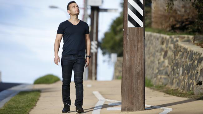 Jerry Mustafa next to a power pole in the middle of the footpath. Picture: David Caird