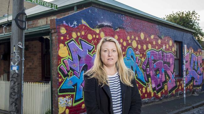 Kate Perkins in front of her rental house where her landlord commissions artists to help deter tagging.