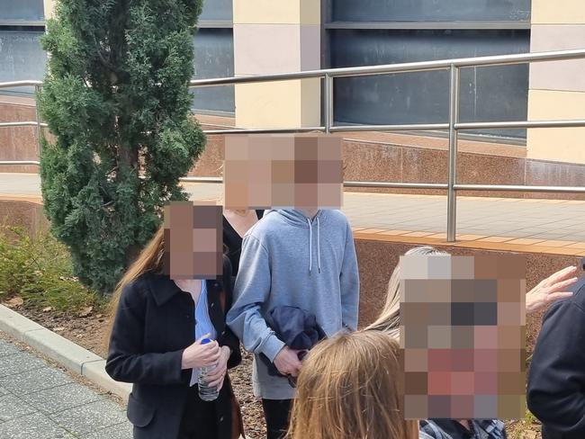 The 15-year-old boy, accused of firing three shots outside his former high school, leaves court with his family after having his bail conditions changed. Picture: NCA NewsWire / Anthony Anderson