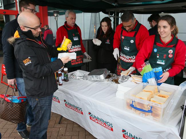 Who doesn’t love a sausage sizzle? Even when it’s freezing! Picture: Mega/news.com.au