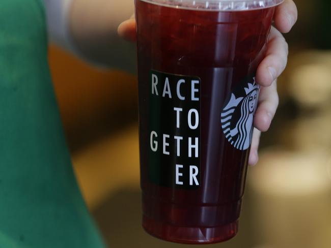 A Starbucks barista holds a cup with a "Race Together" sticker on it. The initiative backfired. Picture: AP Photo/Ted S. Warren